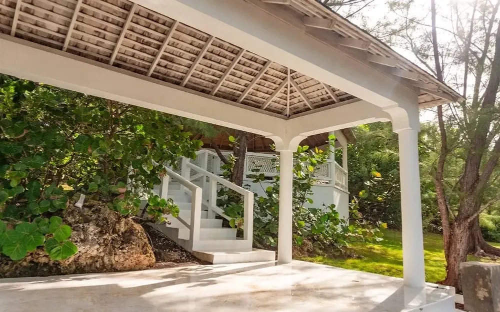 Peaceful white pavilion surrounded by lush greenery in the retreat garden